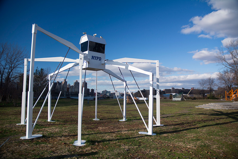 Sculpture of a security booth on long spider legs