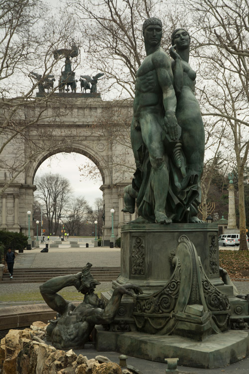 Statues at the center of a water fountain, with Soldiers and Sailors Arch in the background.