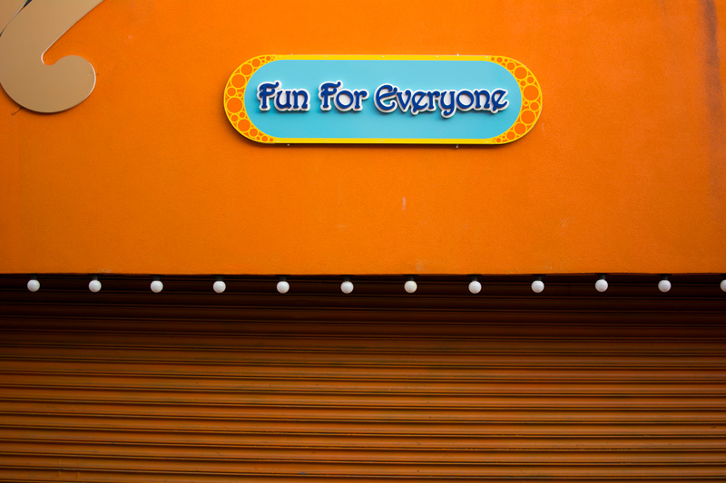 A colorful sign in an amusement park promises fun for everyone.