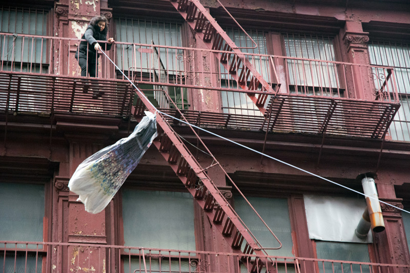 A woman sends a dress down a zip line to a waiting truck.