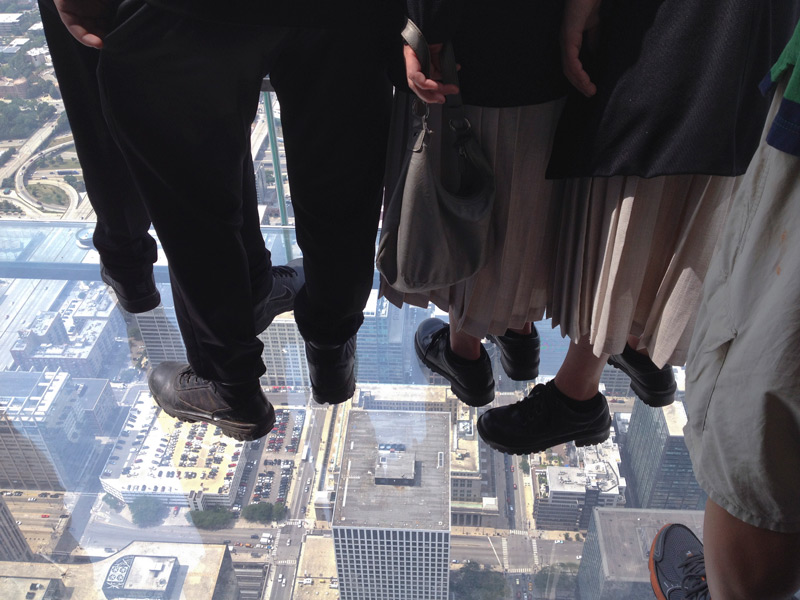 People in a plexiglas viewing overhang in Chicago.