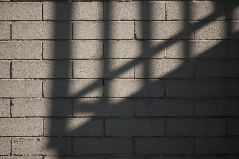 Shadows from a fire escape on a brick wall.
