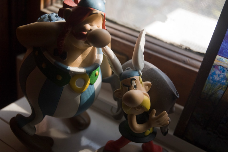 Asterix and Obelix figurines, partially in shadow.