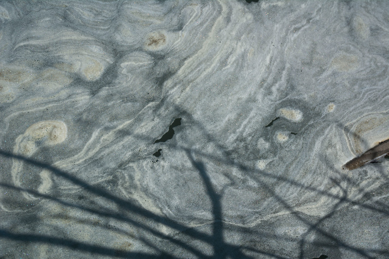 Swirls of foam on the Gowanus Canal.