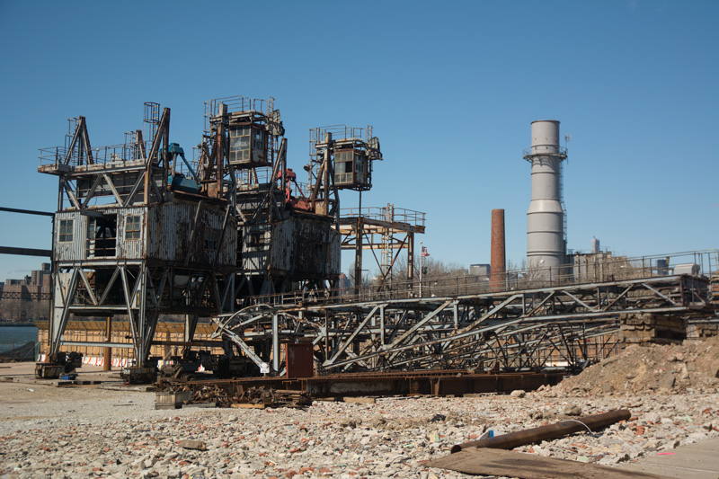 Abandoned industrial structures on a vacant lot.