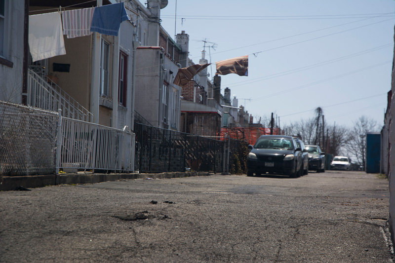 Parked cars and clotheslines on a street.