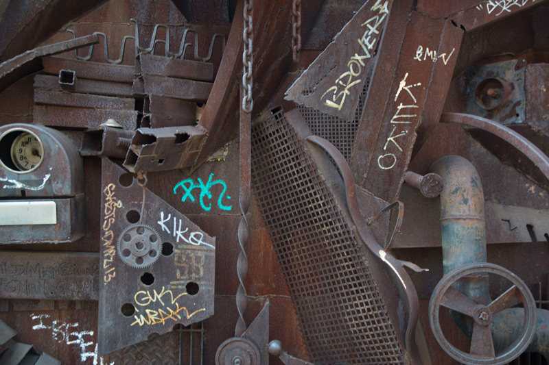 Rusted metal sculpture composed of a hodgepodge of objects.