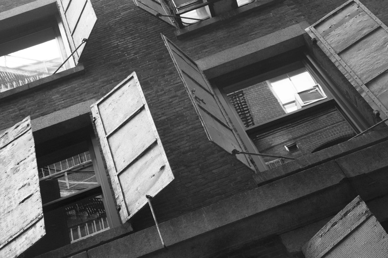 Metal shutters on a building, in different stages of being open.