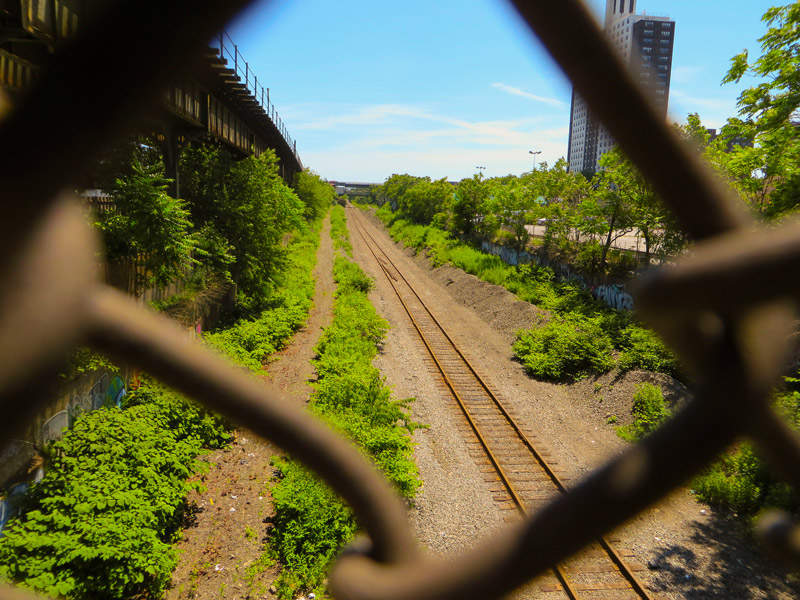 Train tracks, seen through chain link fence.