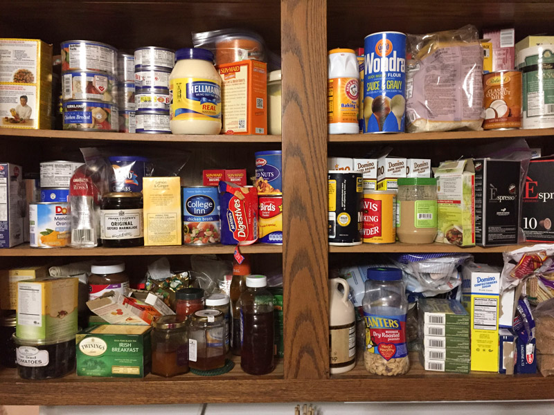 A kitchen cabinet of shelf-stable foods.