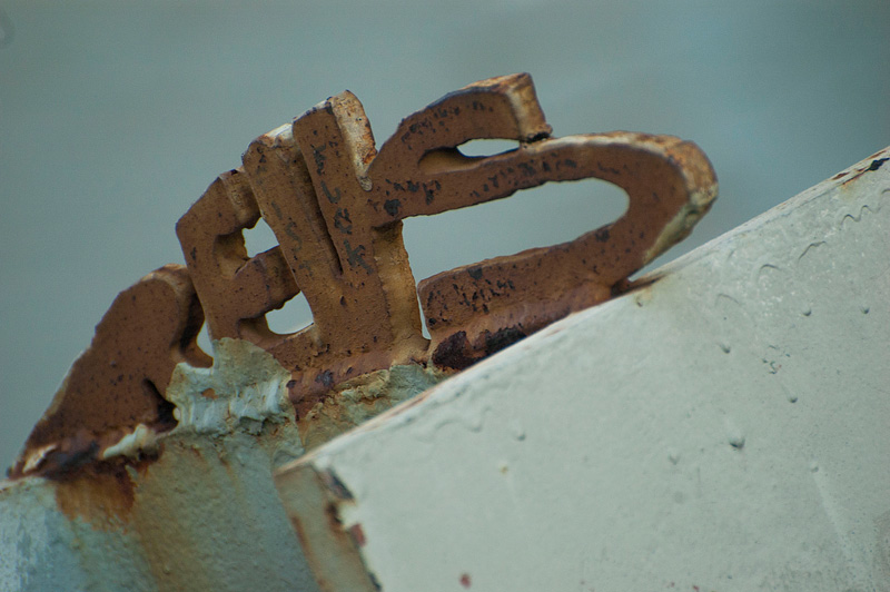 A metal 'Revs' sculpture atop a steel bollard.