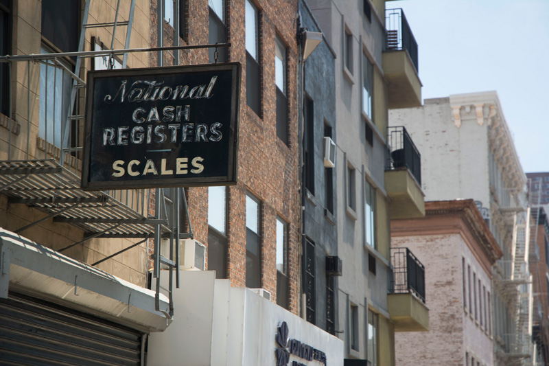 An old, leftover sign advertises cash registers and scales.