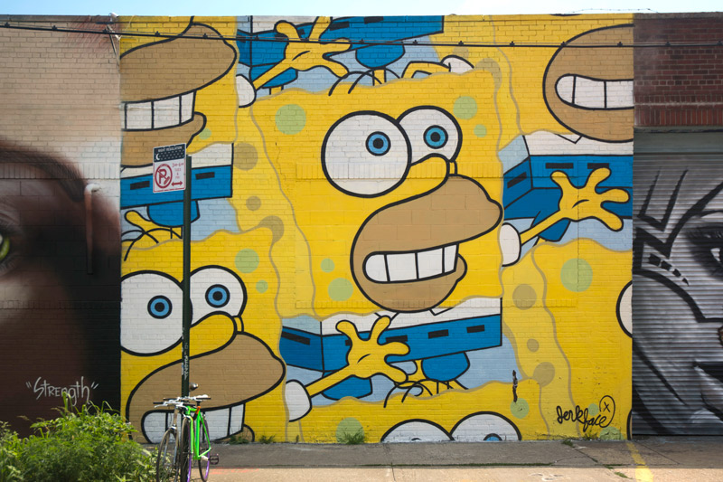 A mural merges Homer Simpson's face into Sponge Bob Squarepants's body.