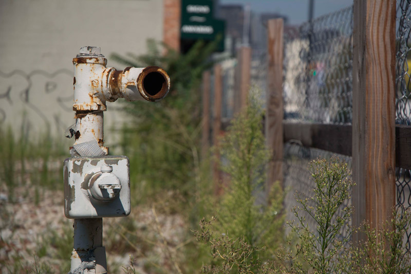 A rusted pipe in an empty lot, connected to nothing.