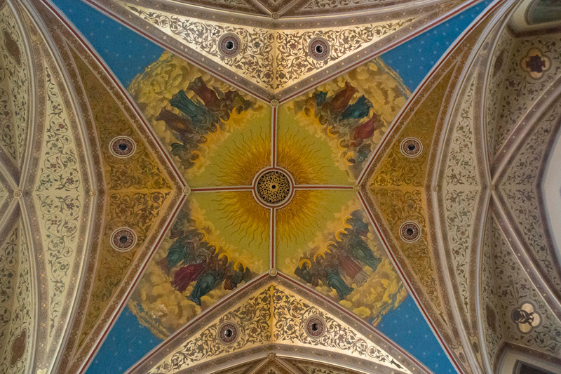 An ornate church ceiling with the Apostles around the sun.