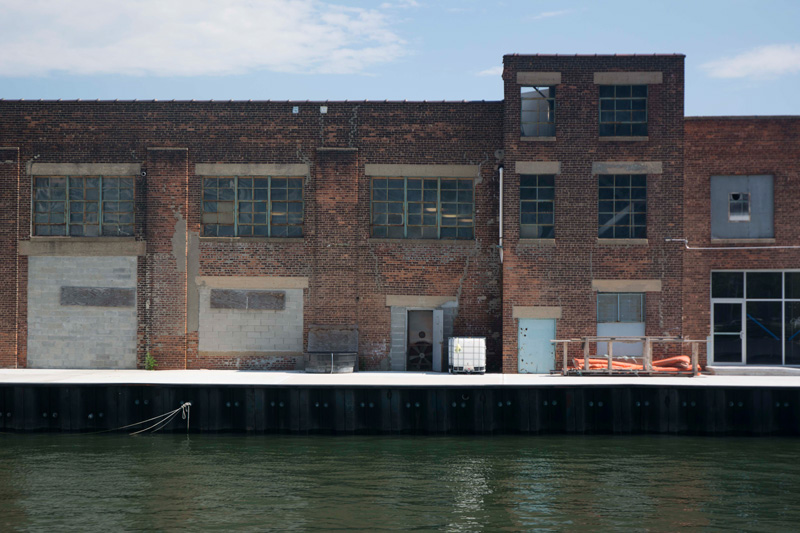 A long, brick, industrial building on a pier.