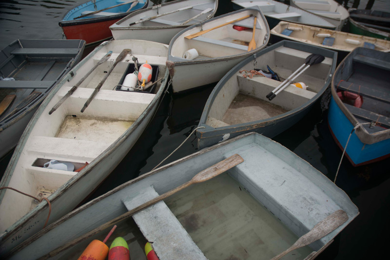 Skiffs at a pier, some with lobster buoys.