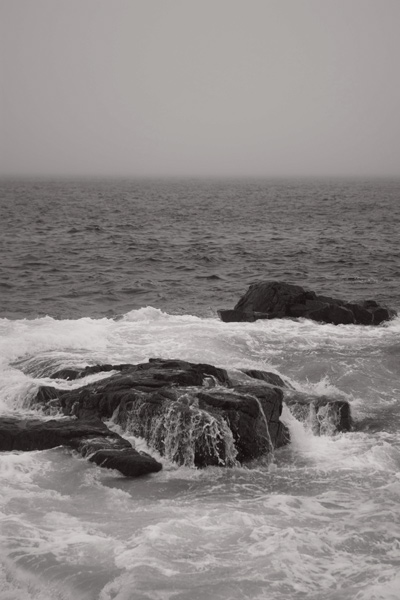 The ocean swirls around rocks on a coasttline
