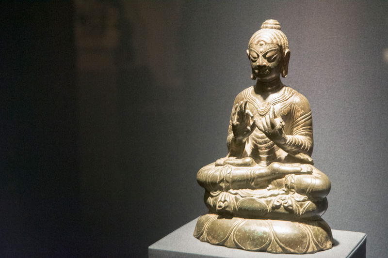 A Buddha statuette, sitting with crossed legs.
