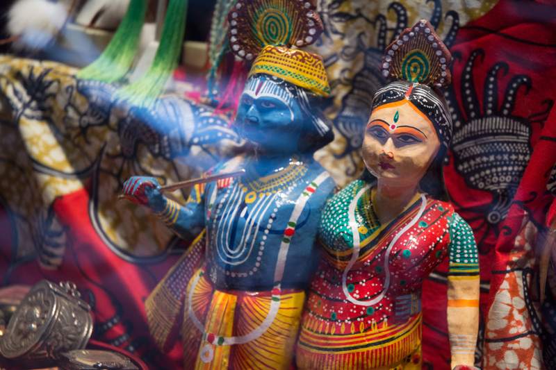 Colorful Latin American figurines in a store window.