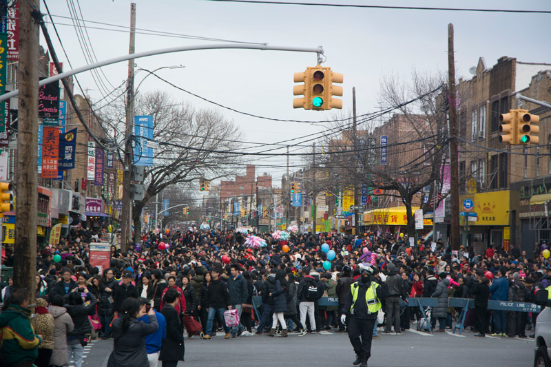 Throngs of people on a street, during a fair.