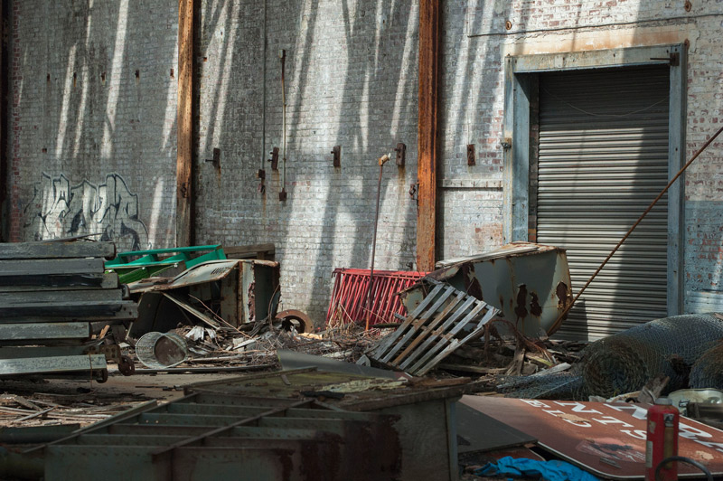 Debris in a room where sun comes through from an open roof.