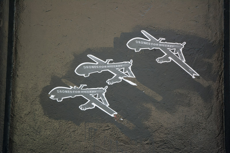 Silhouettes of military drone bombers, labeled with 'Drones For Hillary'.