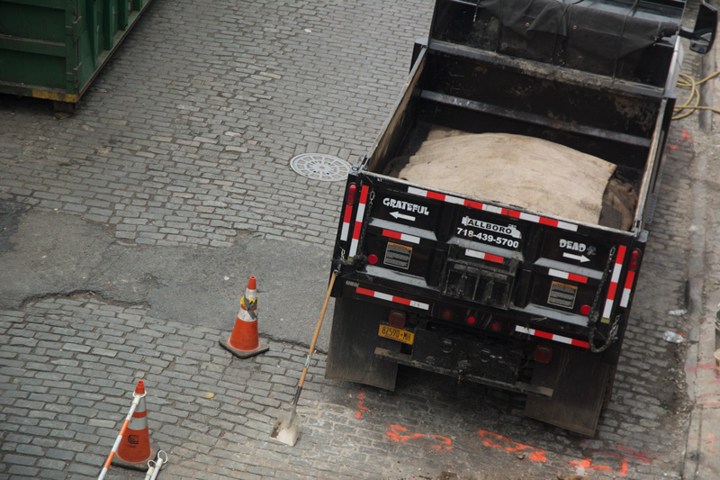 The tailgate of a dumptruck warns passers not to pass on the right, with 'Grateful' painted on the left and 'Dead' painted on the right.