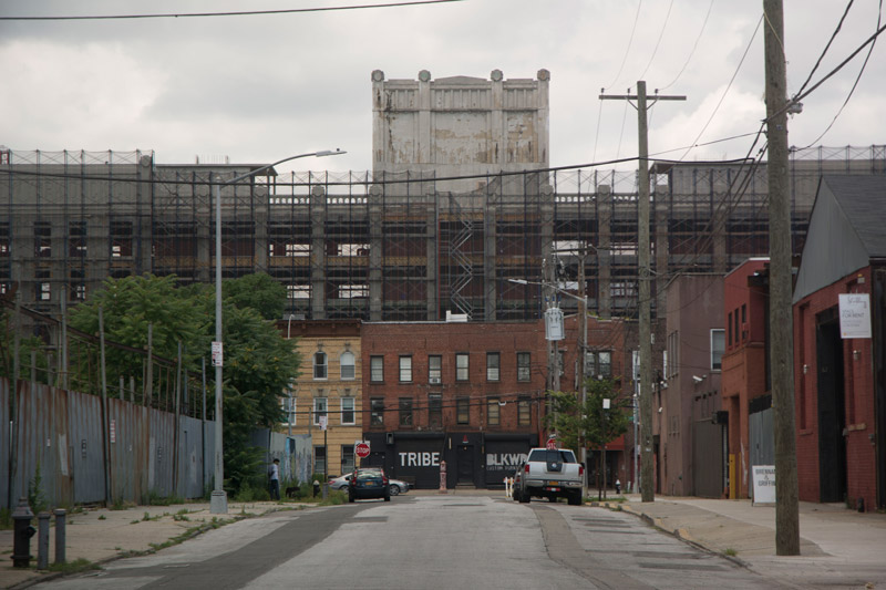 At the end of an industrial street, a building with the word 'Tribe'.