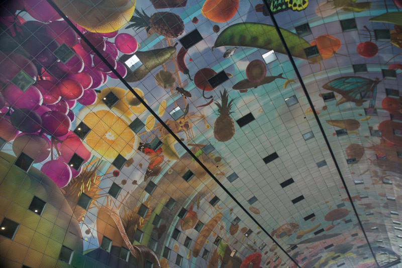 A curved ceiling over a food market, painted with pictures of produce.