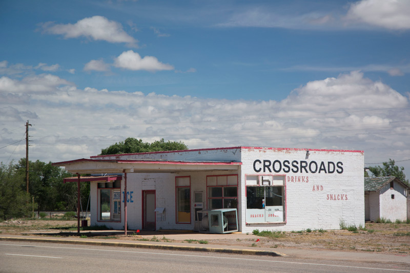 An isolated convenience store called 'Crossroads,' in the bright sun.