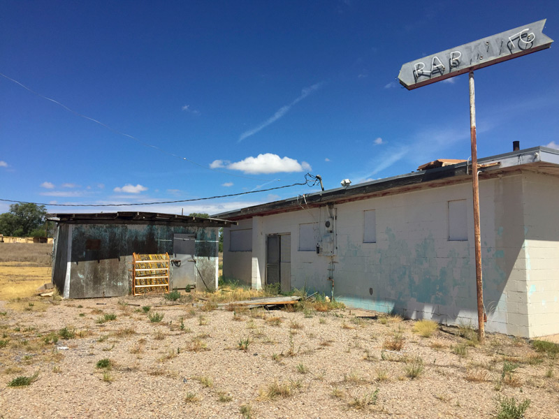 A dead neon sign, whose broken letters used to patrons to parking, at a now-abandoned diner.