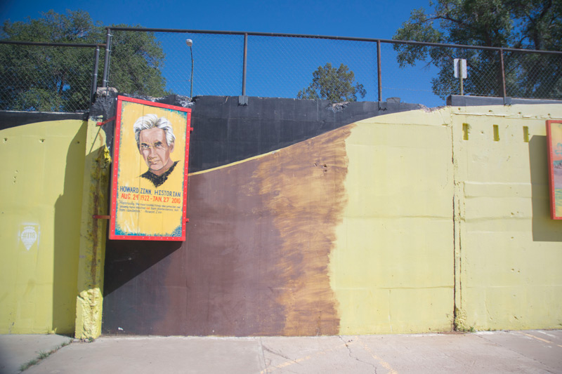 A painting of the historian Howard Zinn, at one end of a parking lot.