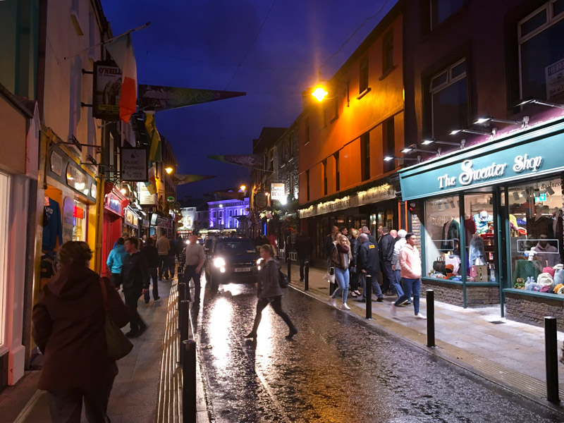A busy commercial street, at night.
