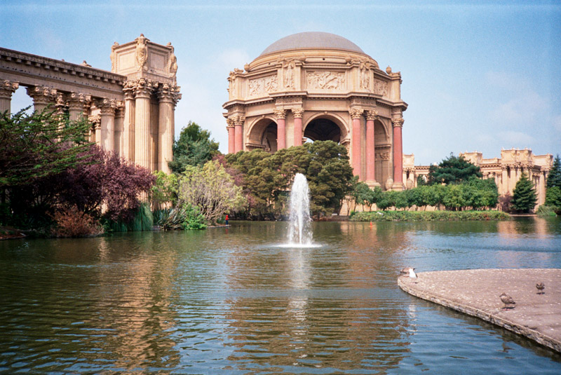 The photo shows the Palace of Fine Arts, consisting of a rotunda surrounded by a pergola and a lagoon.