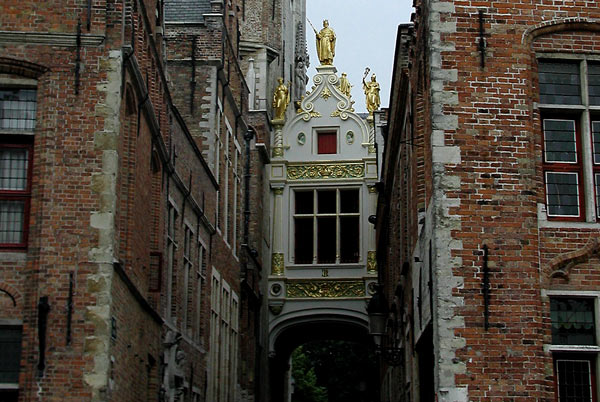 A guilded, white
bridge between old buildings, with statues at the top.