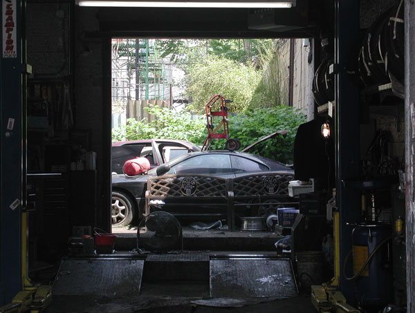 A dark garage,
with a garden at the back.