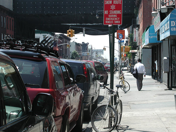 Man walking down street on a hot day, his
suit coat in his hands.