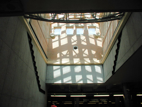 Light from a skylight, broken by crosshatched
supports, illuminate a wall.