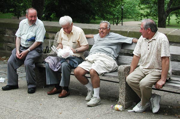 Four retired men sitting on a park bench,
enjoying each others' company.
