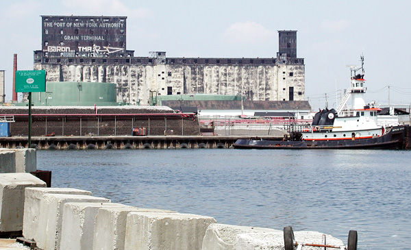 A boat is anchored on the Gowanus Canal, near an
oil tank.