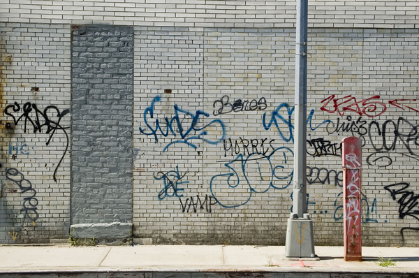 Graffiti covers a wall with white bricks