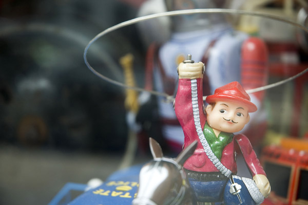 A vintage toy cowboy spins his lasso above his head