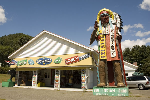 A statue of an American Indian towers over a shop.