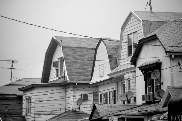 A string of row houses with satellite tv dishes.