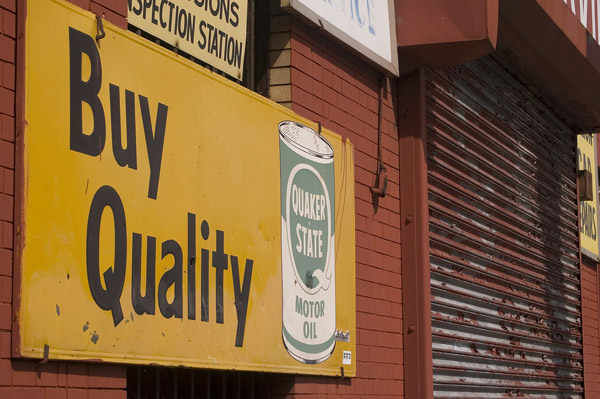 A sign on a garage touts Quaker State oil.