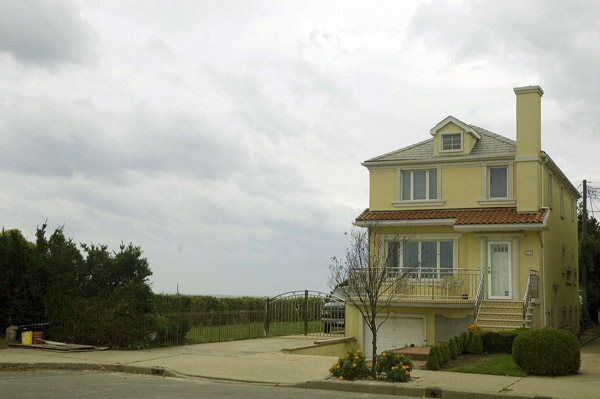 A yellow house has nothing beyond it but sea and
sky.