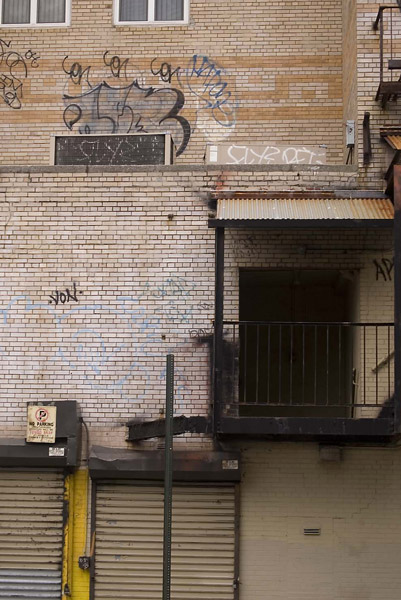 An exit at the top of stairs, under a rusted canopy.