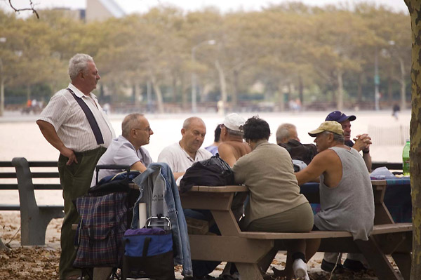 A mix of people at a picnic table by the beach.