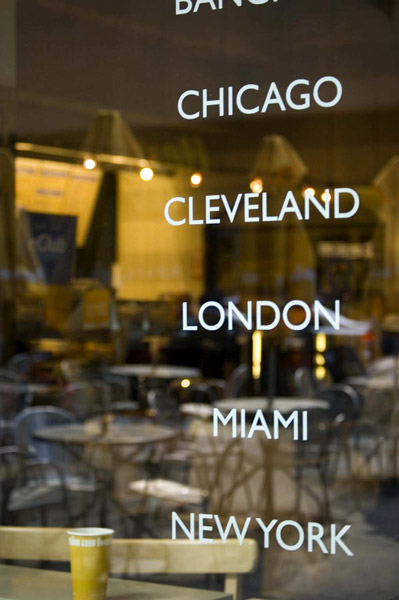 A window with reflections lists the chain's cities.